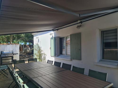 una mesa de madera y sillas en un patio en Villa Babeth by Nuits au Port, en La Rochelle