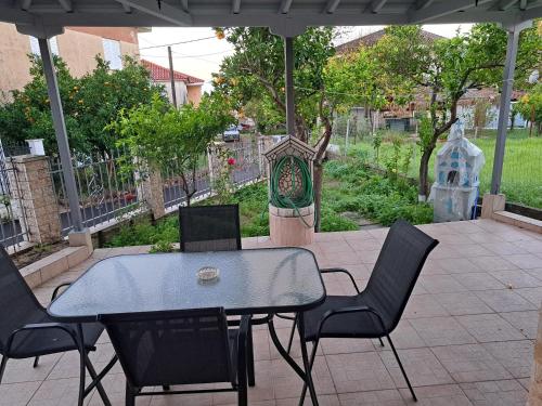 un patio con mesa y sillas y un jardín en Traditional Stone House-Ideal for families, en Archea Pissa