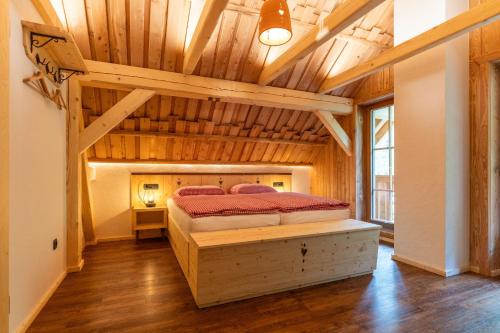 a bedroom with a bed in a room with wooden ceilings at ALPIK Chalets - Bohinj in Bohinj