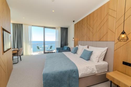 una camera con letto e vista sull'oceano di Hotel Ponta Plaza Conference & Spa a Budua