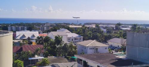 Samolot lata nad miastem z domami w obiekcie Studio Zen Urban climatisé proche aéroport Saint Denis w mieście Sainte-Clotilde