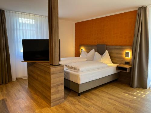 een slaapkamer met een bed en een flatscreen-tv bij WESTSIDE Hotel in München