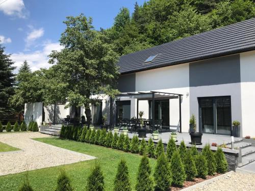 a building with a table and chairs in a garden at Domek szeregowy nr 2 in Tylmanowa