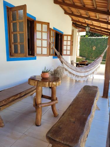 Zimmer mit Hängematte, Tisch und Bank in der Unterkunft Brisa da Serra Hotel Pousada Pirenopolis in Pirenópolis