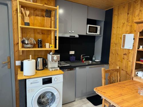 a kitchen with a washer and a washing machine at Apparemment cosy style savoyard in Bourg-Saint-Maurice