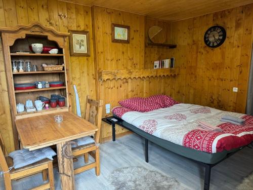 a bedroom with a bed and a table and a clock at Apparemment cosy style savoyard in Bourg-Saint-Maurice