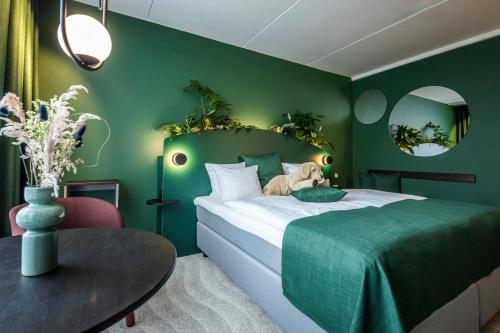 una camera verde con letto e tavolo di The Note a Vejle