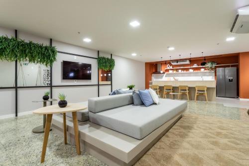 a living room with a couch and a kitchen at Lobie Casa Mauá in Rio de Janeiro