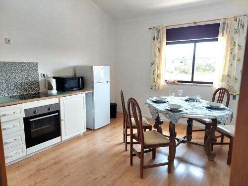 a kitchen with a table with chairs and a refrigerator at Casa Alegria - Apartment Vista da Serra in Tomar