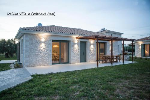 una casa in pietra con patio e tavolo di Anagallis Villas a Città di Lefkada