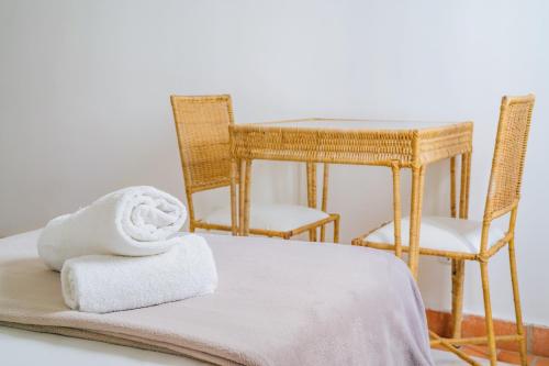 Cette chambre comprend une table avec deux chaises et une serviette. dans l'établissement Pousada Porto Fino, à Cabo Frio