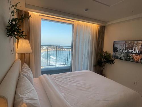 una camera con un letto e una grande finestra di SurfResort INN-The City YangYang a Yangyang