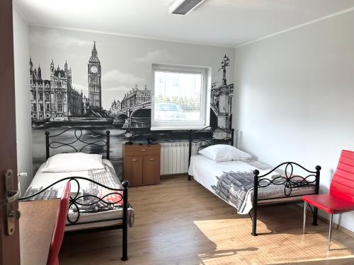 a bedroom with two beds and a picture of big ben at Leo Hostel in Poznań