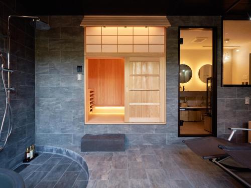 KONJAKUSO Nara Naramachi "MUSHIBUROYA" Sauna Villa في نارا: حمام مع دش وحوض استحمام