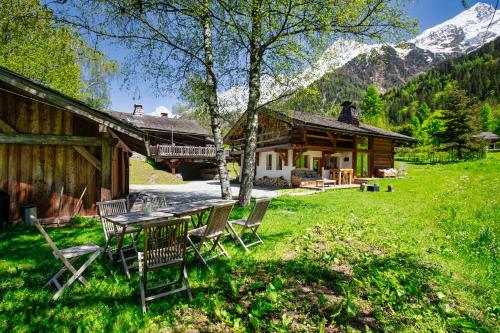 einen Tisch und Stühle vor einer Hütte in der Unterkunft Chalet Taconnaz - Warm & Cosy 3BR Chalet with Fireplace in Nature - By Cozee Rentals in Les Houches