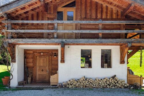 ein Haus mit einem Stapel Feuerholz davor in der Unterkunft Chalet Taconnaz - Warm & Cosy 3BR Chalet with Fireplace in Nature - By Cozee Rentals in Les Houches