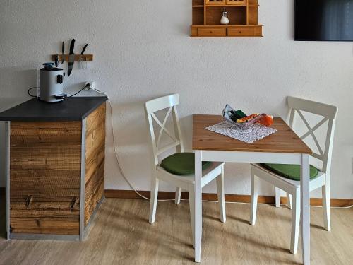 een houten tafel met twee stoelen en een tafel met groenten erop bij Apartment Klein Matterhorn - Haus Miranda in Täsch