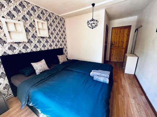 um quarto com uma cama azul num quarto em Jelonkowo em Jelenia Góra