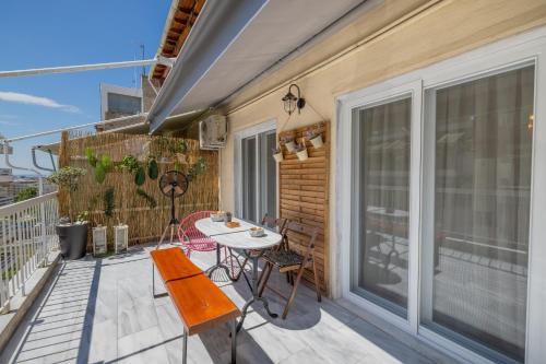 un patio con tavolo e sedie sul balcone. di Elysian Bliss by InFox Suites a Salonicco