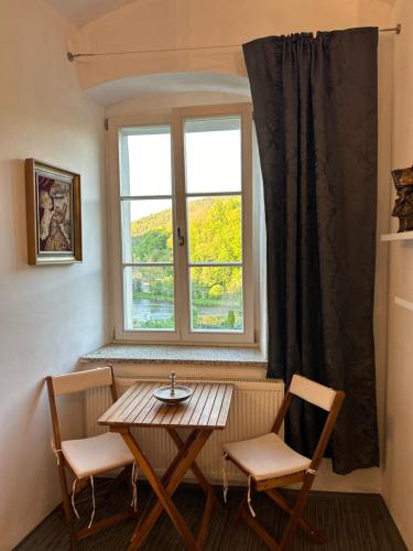 een tafel en stoelen in een kamer met een raam bij Rezidence Napoleon in Loket