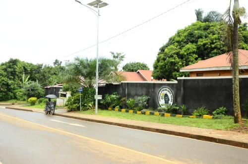 uma pessoa a conduzir uma moto numa rua com um guarda-chuva em Gorilla African Guest House em Entebbe