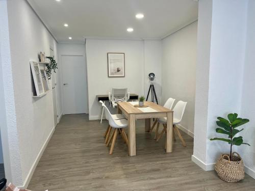 een eetkamer met een tafel en witte stoelen bij En el corazón de Santander in Santander