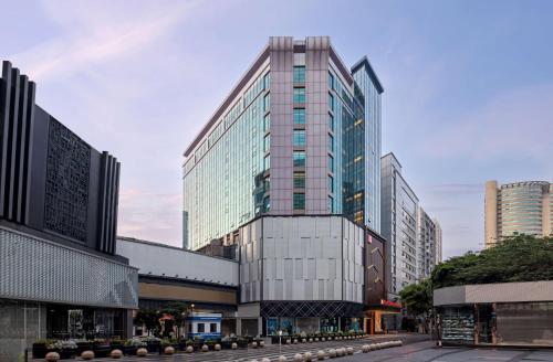 Un edificio di alto vetro nel centro di una città di Hilton Garden Inn Chengdu Chunxi Road Center a Chengdu