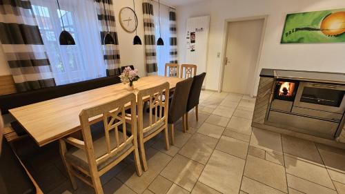 een eetkamer met een tafel en een open haard bij Ferienhaus am Donauspitz in Kelheim