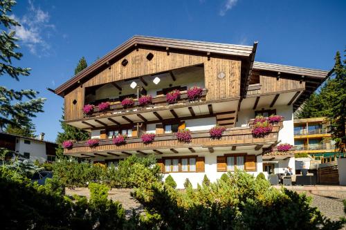 un edificio con un balcón con flores. en Hotel Lajadira & Spa, en Cortina dʼAmpezzo