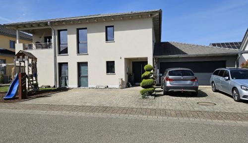 a car parked in a parking lot in front of a house at Gästehaus Ferienwohnung Abendstern in Rust