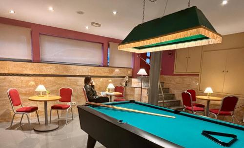 une femme assise au billard dans un restaurant dans l'établissement Hotel Piccadilly Sitges, à Sitges