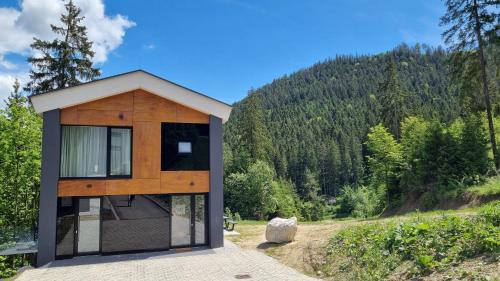 uma casa com uma grande janela do lado de uma colina em Chalets Hrabovo em Ružomberok