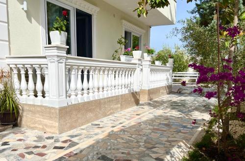 a white railing on a house with flowers on it at Vila Beqja in Durrës