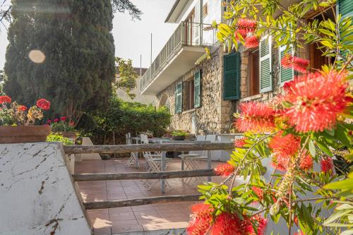 un jardín con mesas y flores frente a un edificio en La Bruna, en Porto Santo Stefano