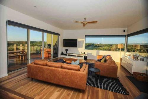 a living room with two couches and a large window at Martyrs Lookout - Luxury Accommodation in Peterborough