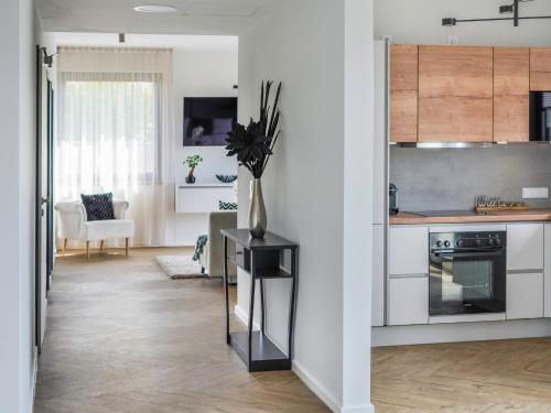 a kitchen with white cabinets and a vase of flowers on a table at Townhome Hotel Hannover - Digital Access - kontaktloser Check-in in Hannover