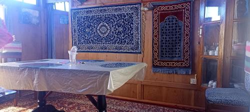 een kamer met een tafel en een wandtapijt bij Houseboat Blue Dolphin in Srinagar