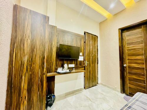 a hotel room with a wooden wall with a television at Hotel KR 5Mins Walk From Golden Temple in Amritsar