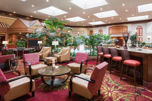 een bar in de lobby van het hotel met stoelen en tafels bij Chicago Marriott Northwest in Hoffman Estates