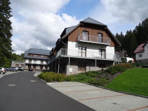 un bâtiment avec un balcon sur le côté d'une route dans l'établissement Penzion Dominik, à Železná Ruda