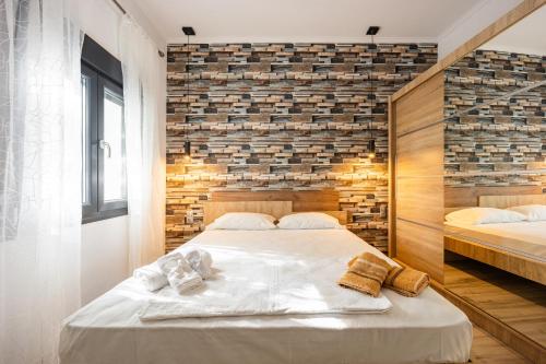 a bedroom with two beds and a brick wall at MonteCasa in Epanomi