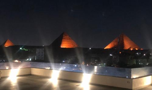 Blick auf ein Gebäude mit Pyramiden in der Nacht in der Unterkunft Nine Pyramids View Hotel in Kairo