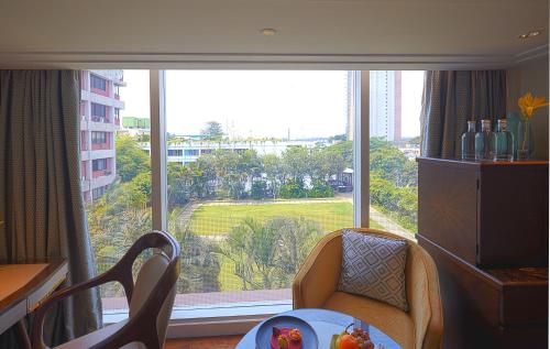 Zimmer mit einem großen Fenster mit einem Tisch und Stühlen in der Unterkunft Taj MG Road Bengaluru in Bangalore