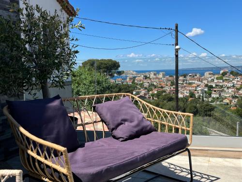 una sedia in vimini con cuscino viola sul balcone di Les Balcons du Roucas Blanc a Marsiglia