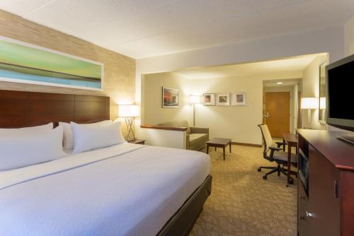 Holiday Inn Baltimore BWI Airport, an IHG Hotel في لينثيكوم هايتس: غرفة الفندق بسرير كبير ومكتب