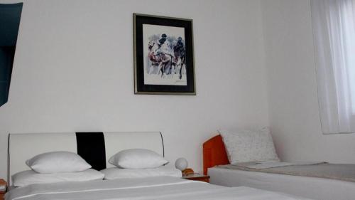 1 dormitorio con 2 camas y una foto en la pared en Holiday In Bihać, en Bihać