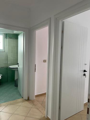 La salle de bains est pourvue de deux portes coulissantes et d'un lavabo. dans l'établissement Guesthouse Butrinti, à Ksamil