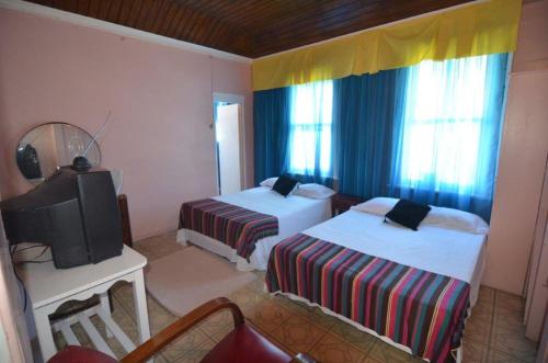 een hotelkamer met 2 bedden en een televisie bij Holiday Home - Guest House in Port Antonio