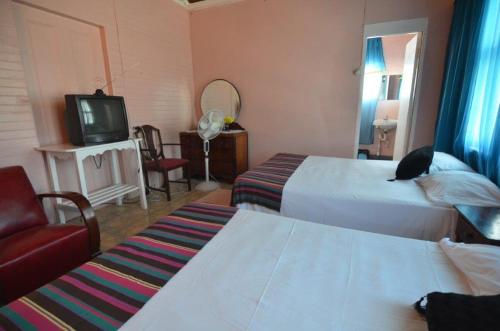 een hotelkamer met 2 bedden en een televisie bij Holiday Home - Guest House in Port Antonio