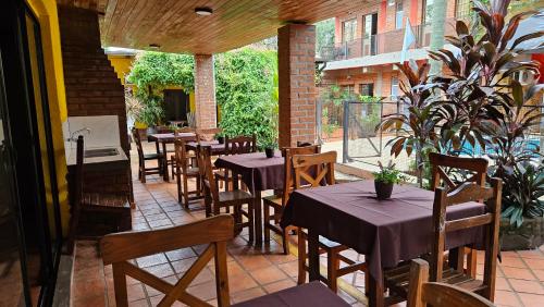 - un restaurant avec des tables et des chaises sur la terrasse dans l'établissement Iguazu Hojas Verdes, à Puerto Iguazú